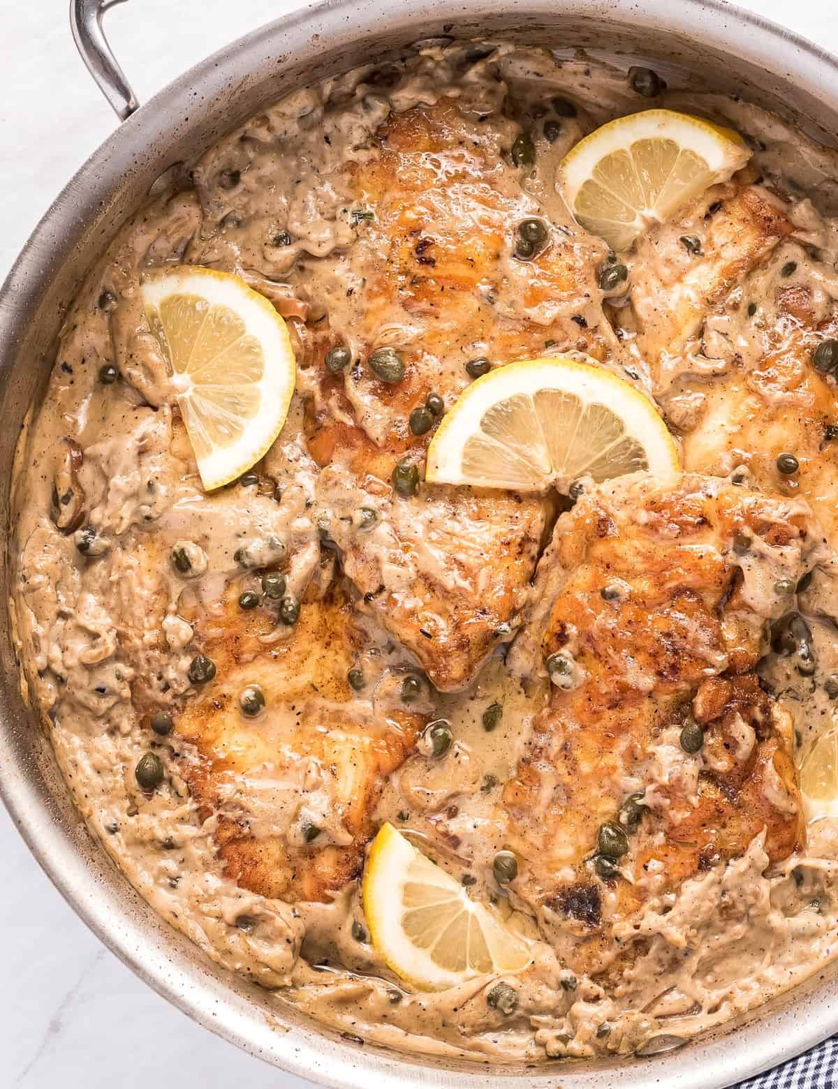 Tender chicken cutlets, lightly breaded and served in a mouthwatering lemon cream sauce with capers and shallots. Great over pasta and ready in about 30 minutes! #piccata #chicken #italian #30minutemeal