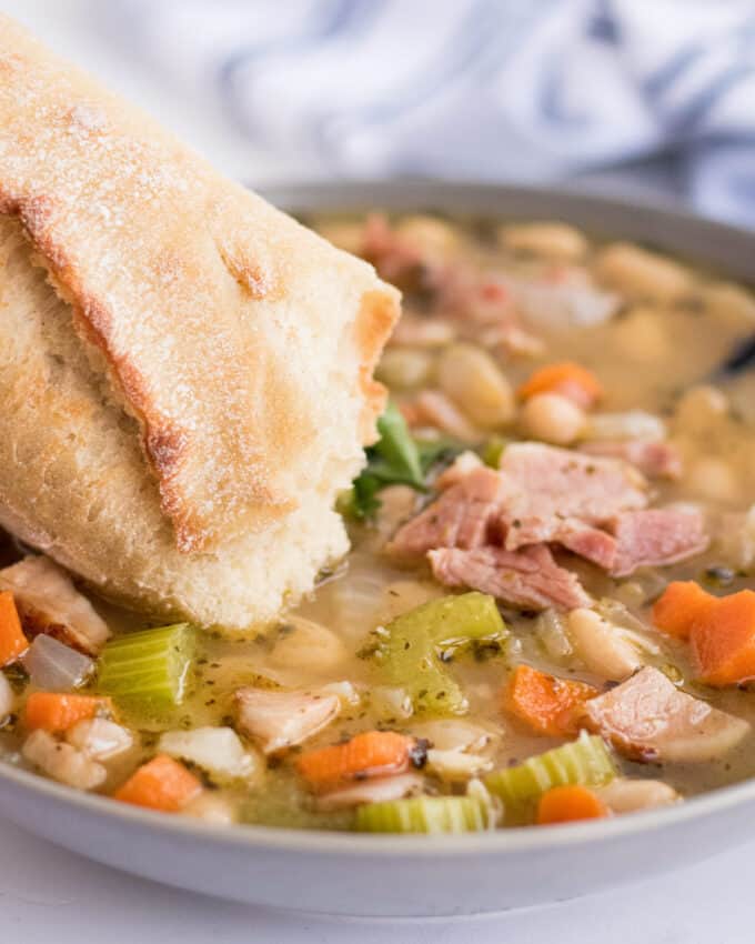 dipping bread into bean soup