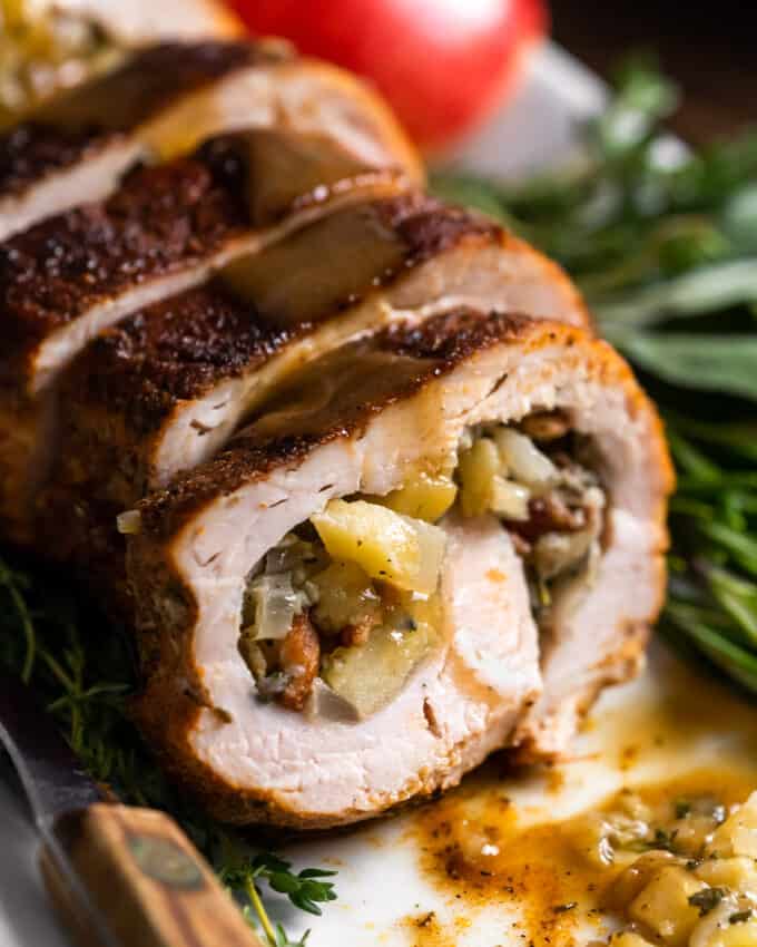 sliced pork tenderloin with gravy on white platter