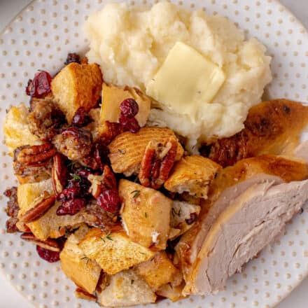 holiday plate of sausage stuffing, turkey, and mashed potatoes