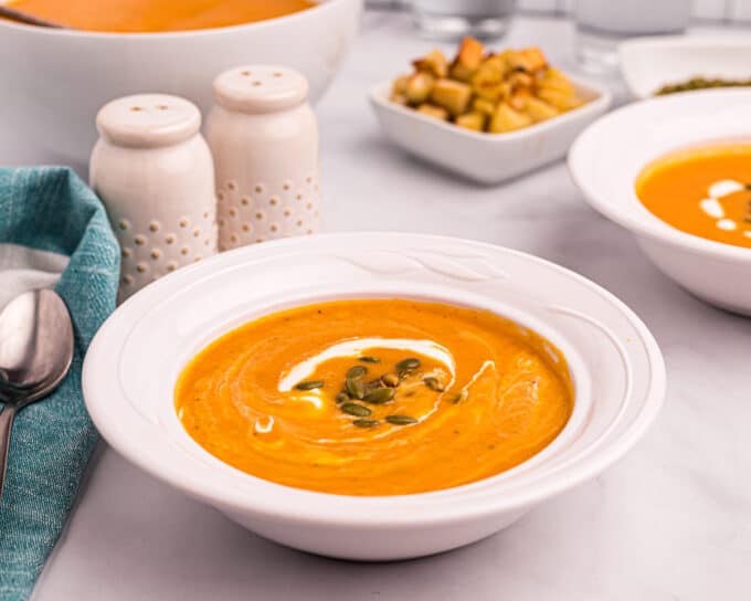 bowl of butternut squash soup with cream and croutons