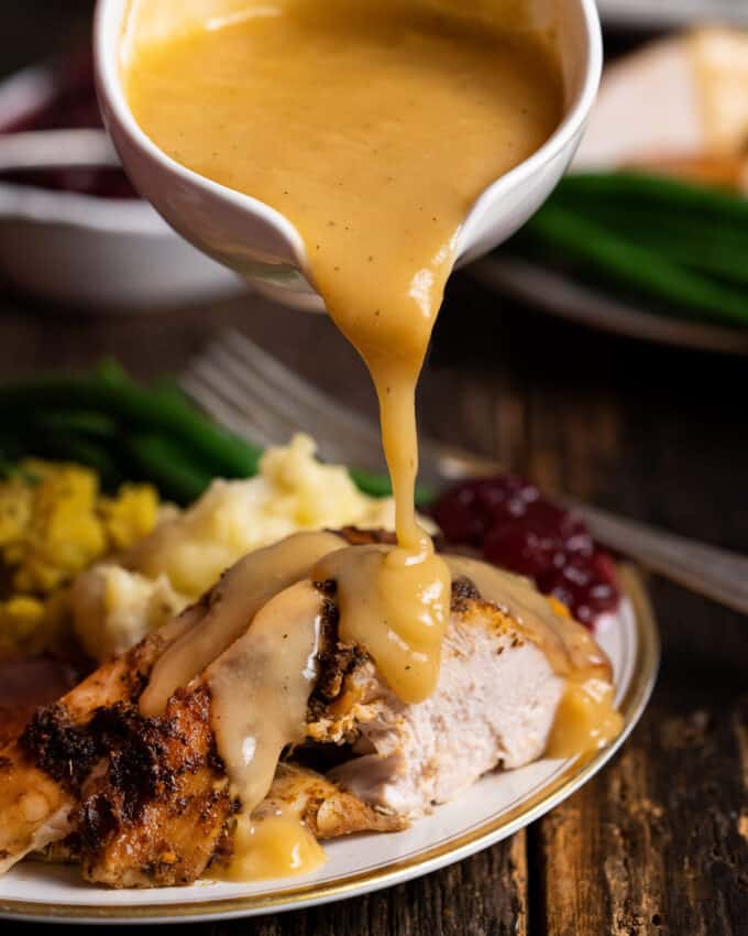 pouring gravy over turkey breast slices