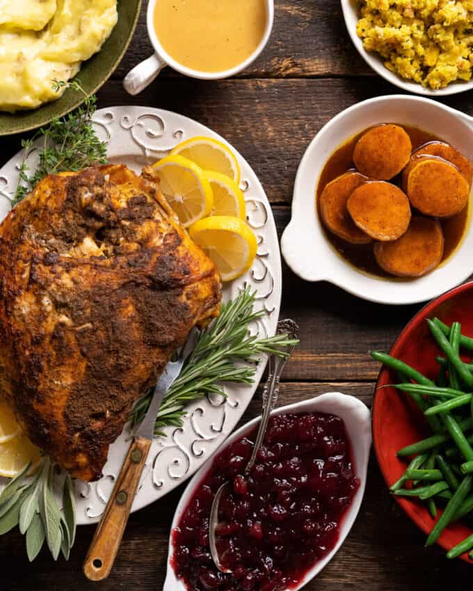 platter with turkey breast surrounded by thanksgiving side dishes