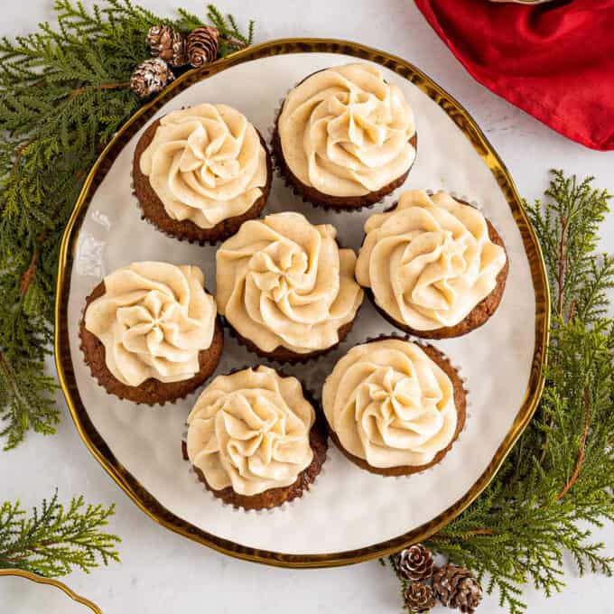 seven gingerbread cupcakes on gold rimmed white plate