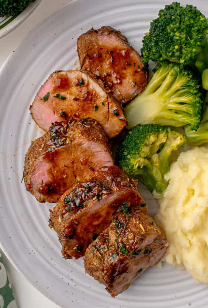 dinner plate with slices of pork tenderloin mashed potatoes and broccoli