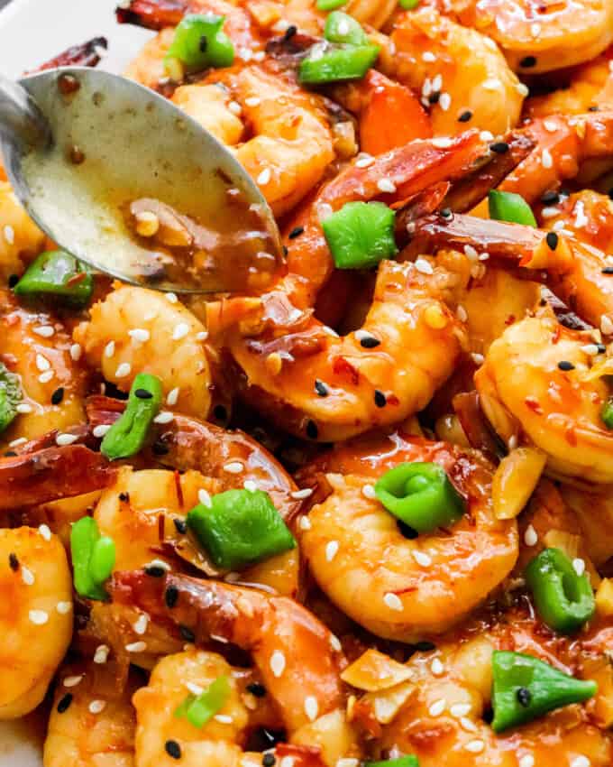 drizzling chili garlic sauce over shrimp