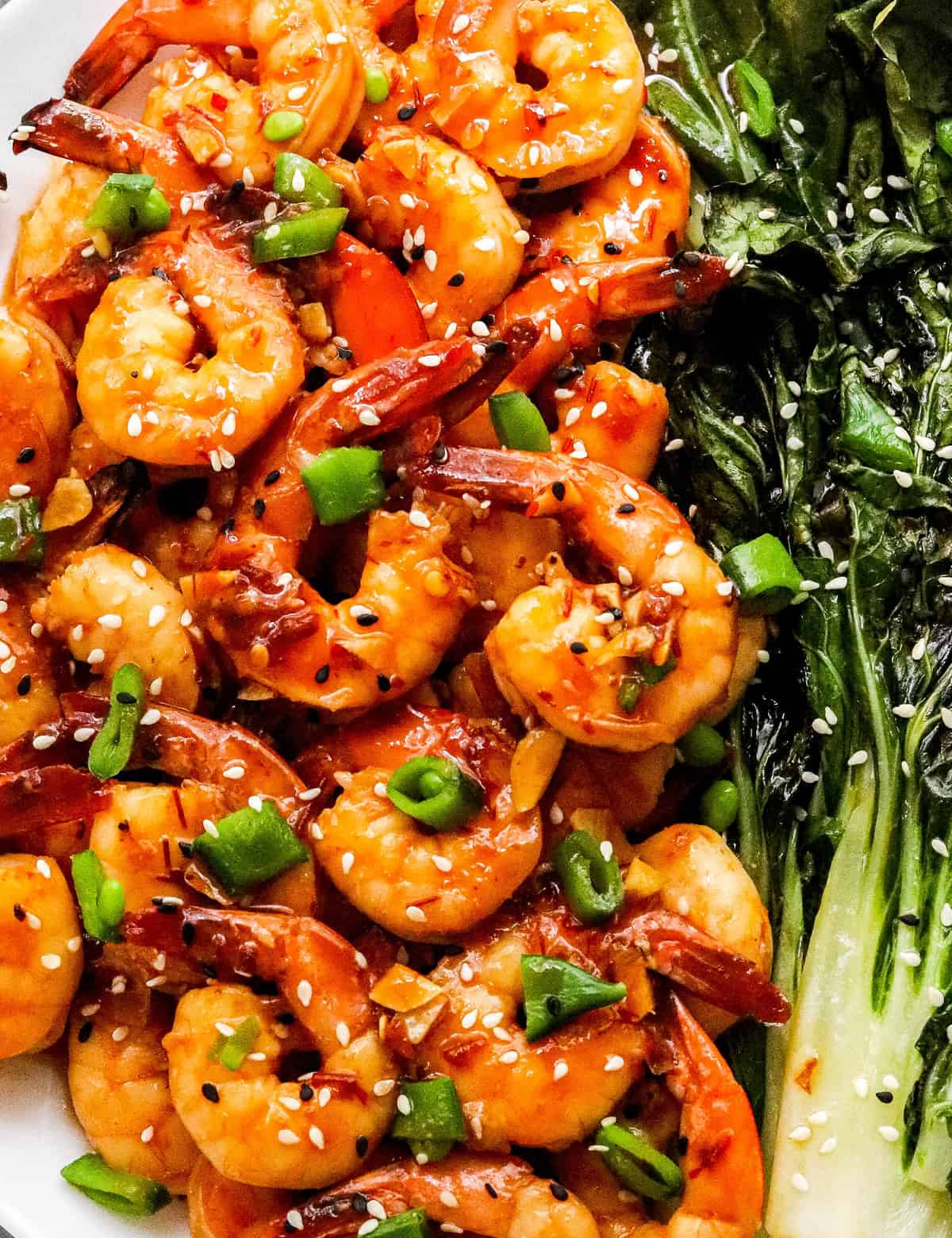 This easy sheet pan meal has shrimp and baby bok choy tossed in a mouthwatering chili garlic sauce, then cooked together on a baking sheet. Dinner is ready in 20-30 minutes, and you have way less dishes to wash! #shrimp #sheetpan #bokchoy