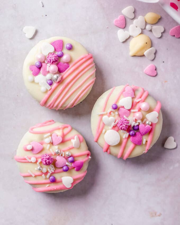 three Oreo cookies covered in chocolate and decorated for valentine's day