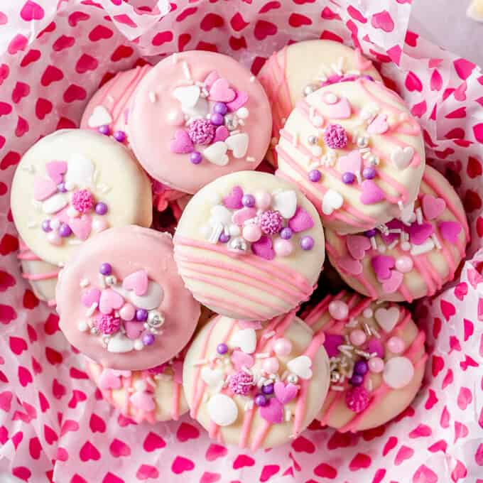 pile of chocolate covered oreos in basket with heart stamped paper for valentine's day