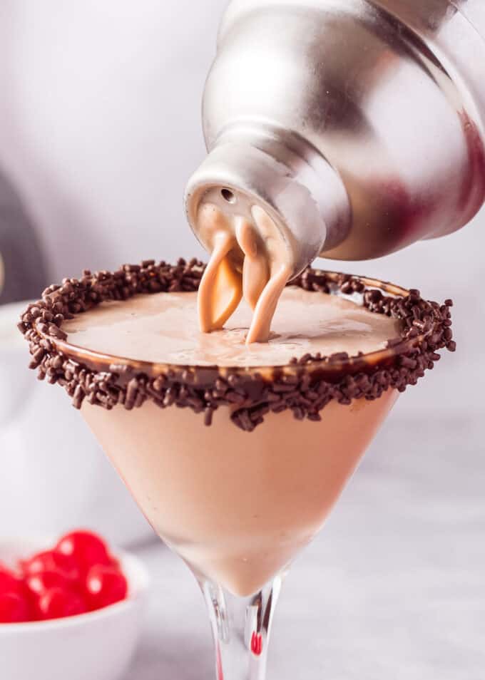 pouring chocolate martini from cocktail shaker into glass