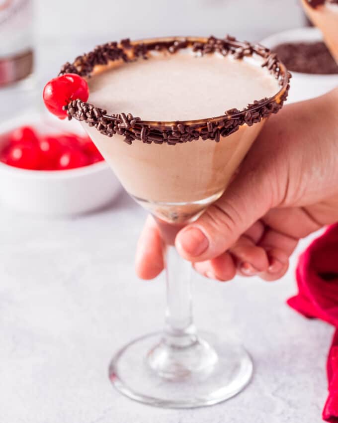 holding a chocolate martini with chocolate sprinkle rim