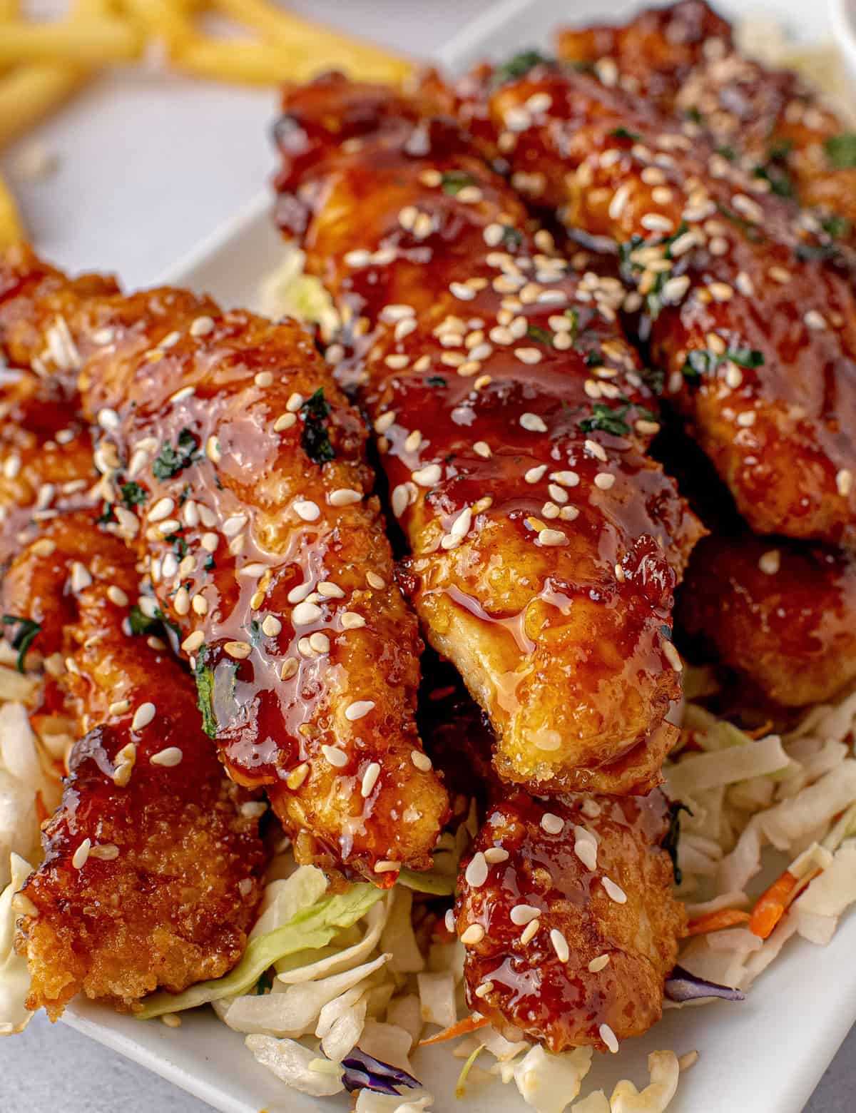 Crunchy chicken strips breaded simply and fried to crispy perfection, then tossed in a mouthwatering whiskey glaze! This copycat recipe tastes just like that appetizer from TGI Fridays, and is perfect for any party or fun dinner! #sesamejack #tgifridays #chickenstrips