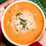 bowl of creamy tomato basil soup with Parmesan cheese and basil