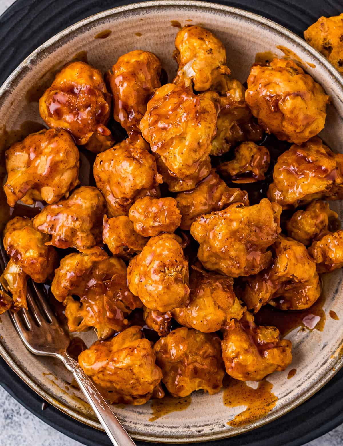 These Honey Chipotle Air Fryer Cauliflower Bites are perfectly crispy, hearty, made easily in the air fryer, and coated in the most mouthwatering honey chipotle sauce! This recipe is a copycat of Chili's honey chipotle chicken crispers, but made vegetarian by using cauliflower instead of chicken. #cauliflower #airfryer #copycat #chilis