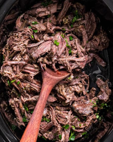This Mississippi Pot Roast is made with no packets (from scratch), and is deliciously savory, buttery, and has the most beautiful tangy kick from the pepperoncini peppers! Made in the slow cooker or Instant Pot, it's a perfect family meal everyone will love. Great with mashed potatoes, in sandwiches, and more! #potroast #mississippi #beef #slowcooker