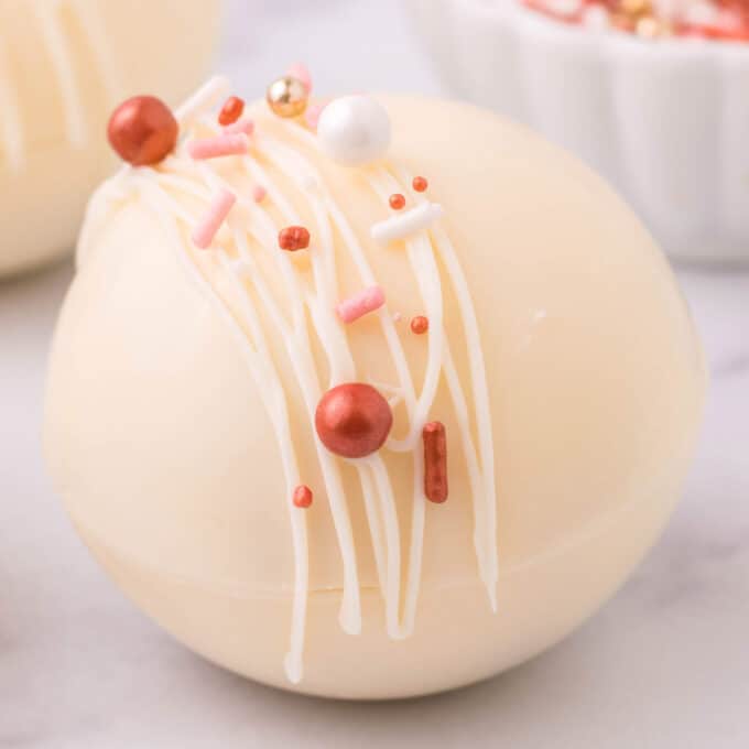 white chocolate hot chocolate bomb decorated with sprinkles