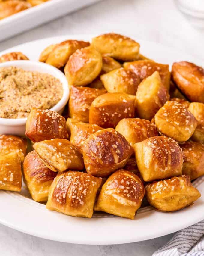 pretzel bites on white plate with cup of mustard