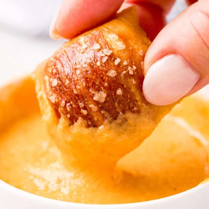 soft pretzel bite dipped in cheese sauce