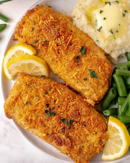 These breaded pork chops are baked to juicy perfection and ready in about 30 minutes! Pork chops are slathered with a thin layer of mayonnaise (which keeps the meat super moist), and breaded with a perfectly seasoned breadcrumb/Parmesan cheese mixture. #porkchops #shakeandbake