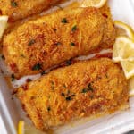 breaded pork chops on baking sheet with lemons