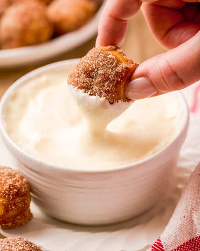 dipping a pretzel bite into cream cheese dip