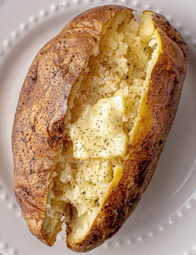Baked Potatoes made in the air fryer are absolutely the best! Potatoes are rubbed with a garlic herb salt rub, then cooked to perfection in the air fryer, without having to heat up your whole house with the oven. Ultra crispy and flavorful skins and fluffy creamy insides... ready to eat!