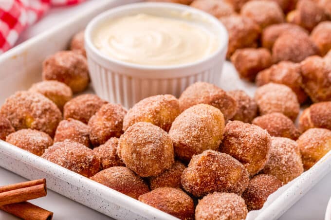 baking sheet full of pretzel bites with a ramekin of dip