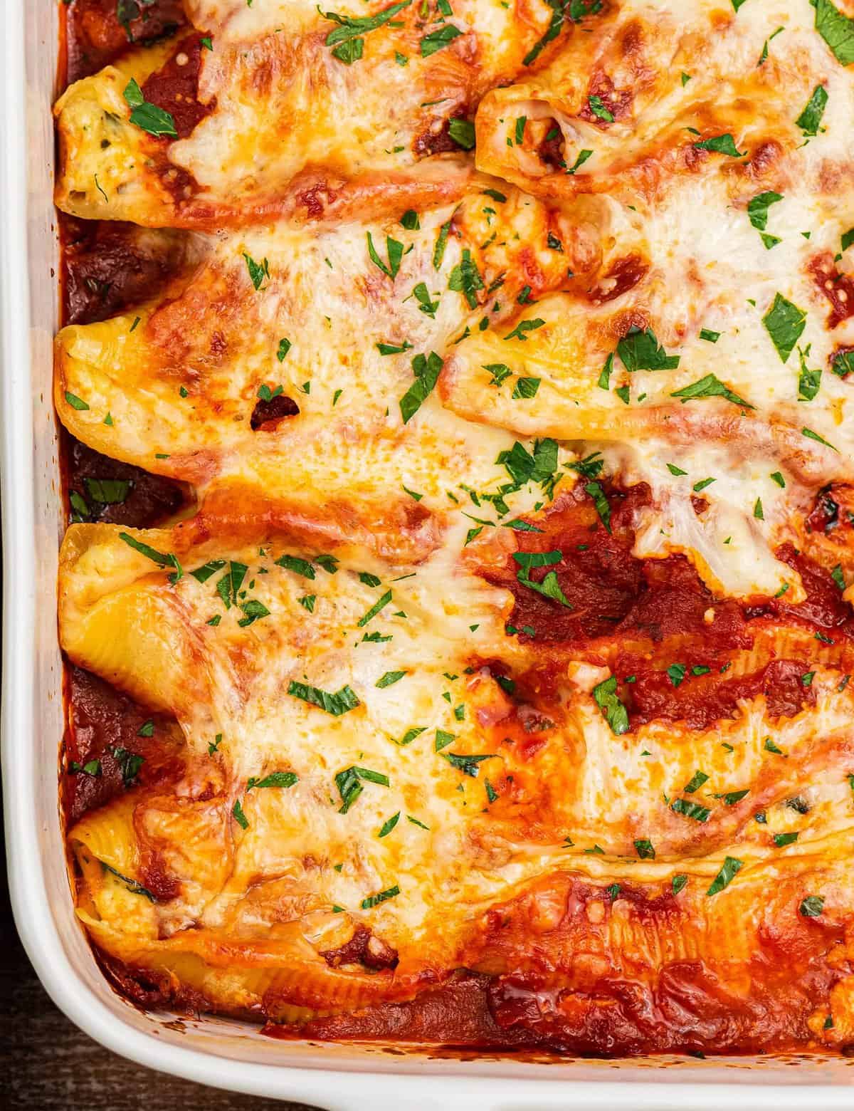 Pasta shells are stuffed with a cheesy ricotta, spinach and garlic filling, then smothered in marinara sauce and mozzarella cheese and baked until bubbly and golden brown! Perfect as a make-ahead dinner idea, and it's freezer-friendly as well.