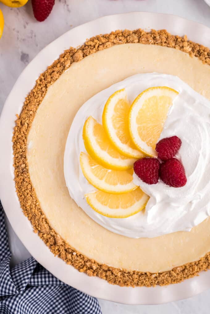 overhead view of lemon pie with whipped cream and raspberries