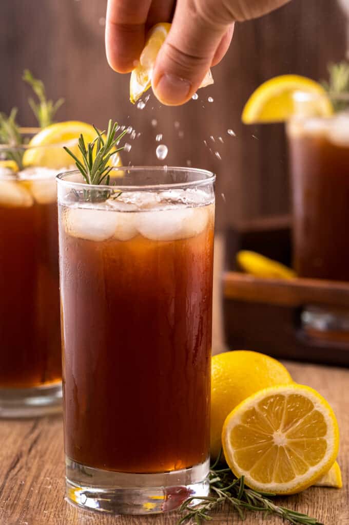 squeezing lemon into a glass of sweet tea