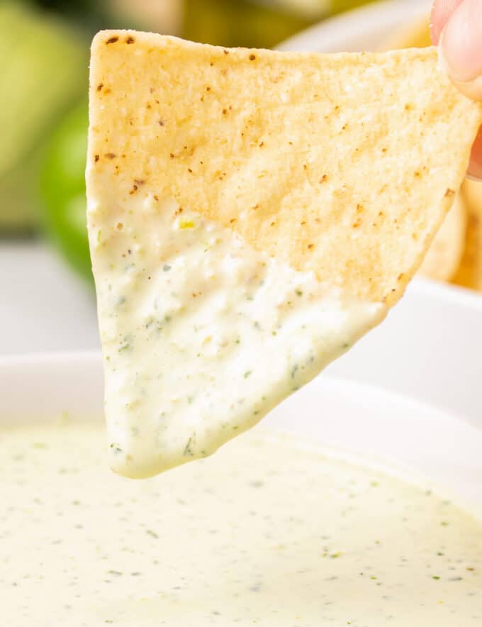 tortilla chip dipped into creamy jalapeño dip