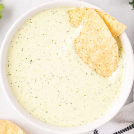 white bowl of creamy jalapeño dip with chips