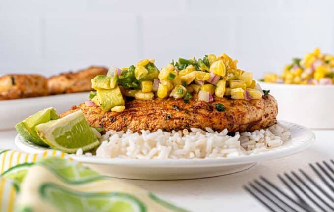 tequila lime chicken on plate with rice, topped with corn salsa