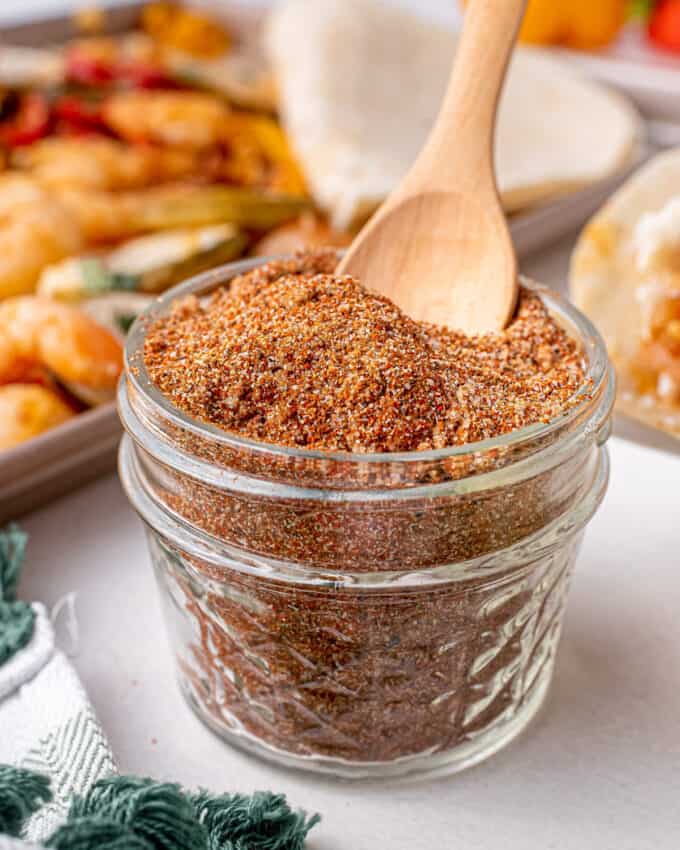 glass jar of fajita seasoning blend with scoop