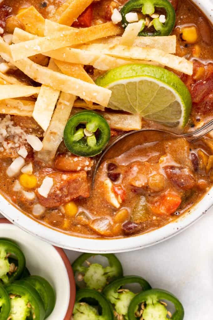 close up of a spoonful of vegetarian tortilla soup in the soup bowl