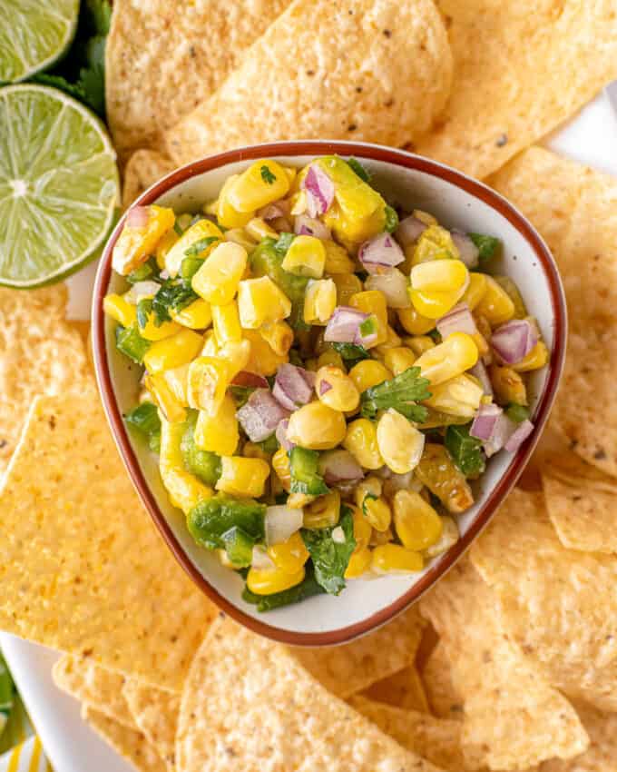 corn salsa in small bowl surrounded by tortilla chips