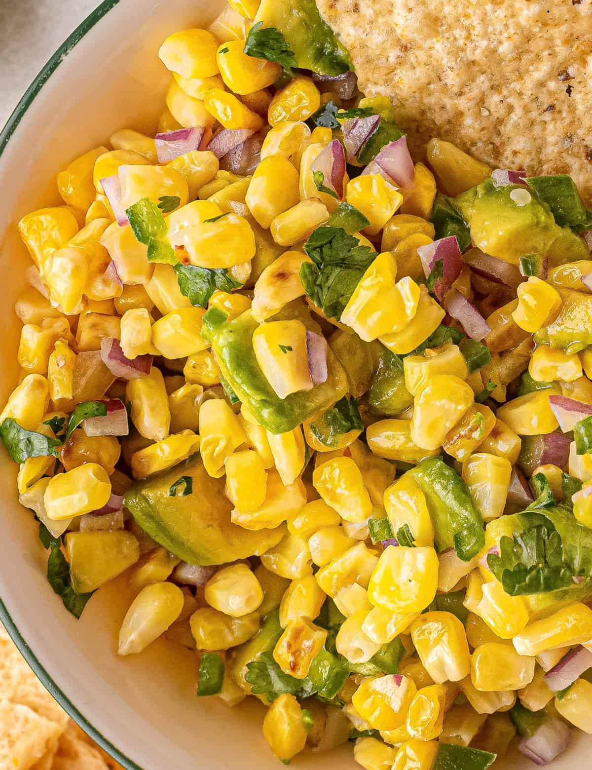 Amazing corn salsa that's loaded with bold flavors! Sweet corn, crunchy jalapeños and onion, buttery avocado and tangy lime juice... this salsa is perfect with a big bowl of chips, or loaded up onto tacos, burritos and more!