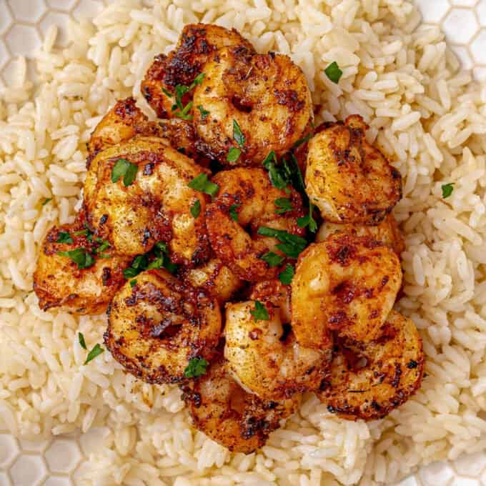 blackened shrimp on a bed of white rice on plate