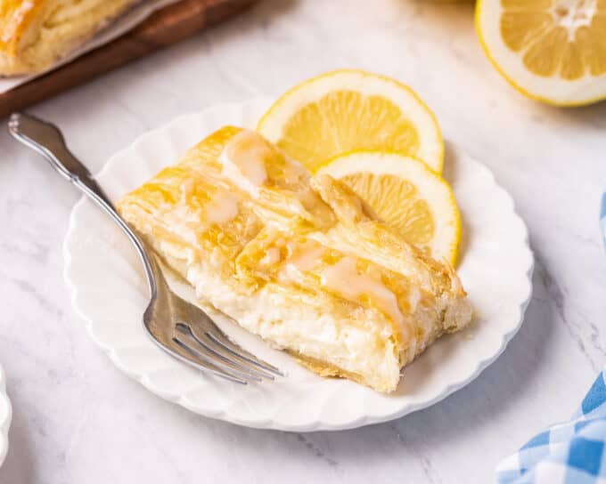 slice of lemon cheese danish on white plate with fork