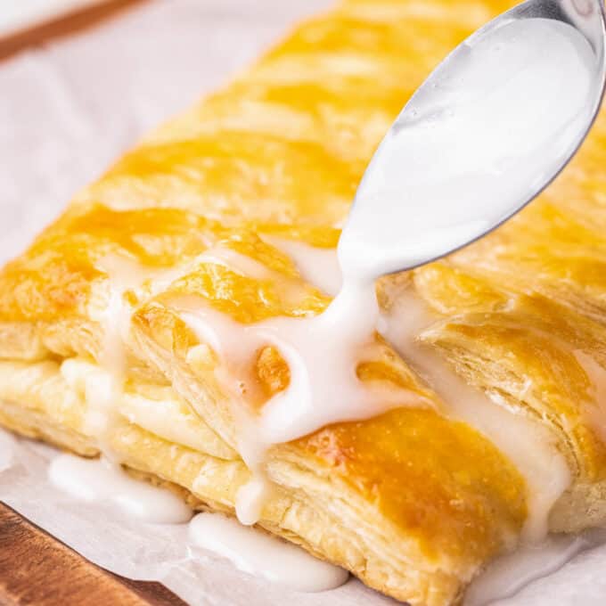 drizzling sweet glaze over lemon cheese danish