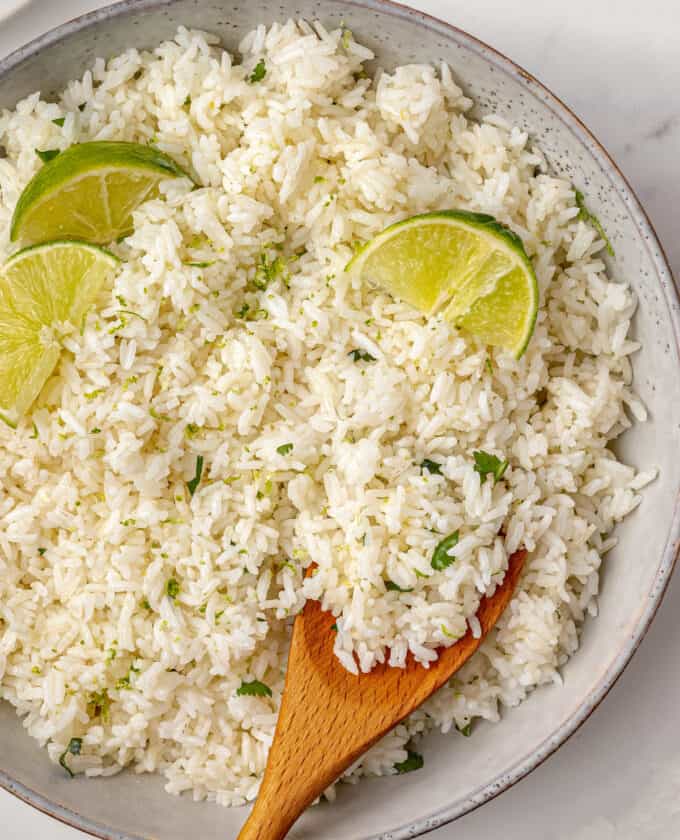 wooden spoon in a bowl of cilantro rice