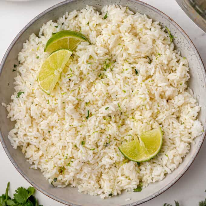 cilantro lime rice in grey bowl garnished with lime slices