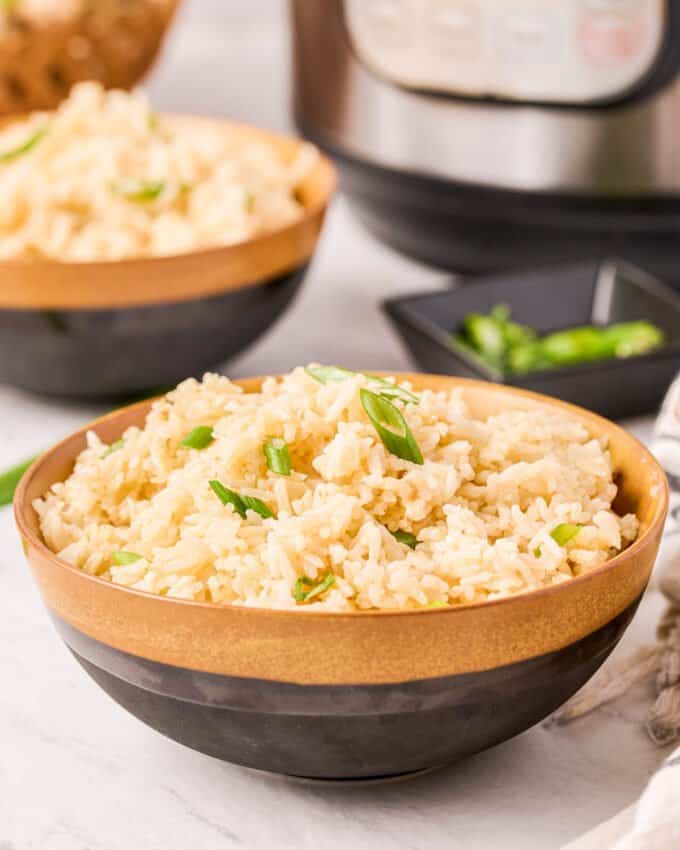 two bowls of ginger rice with instant pot in the background