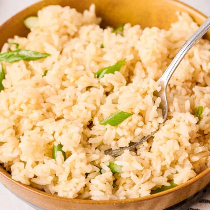 bowl of ginger rice with green onions and a spoon in the bowl