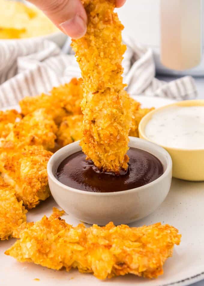 dipping chicken tender into bbq sauce