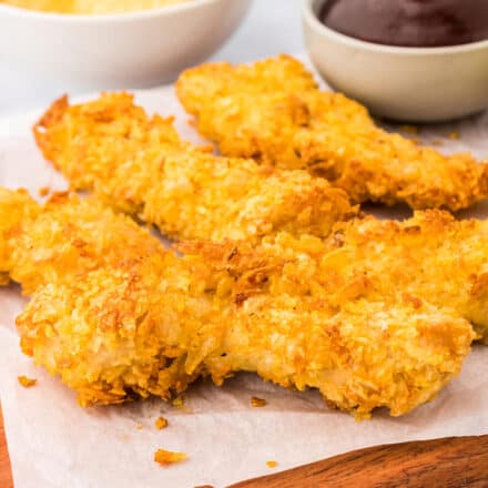 pile of air fryer chicken tenders on cutting board with parchment paper
