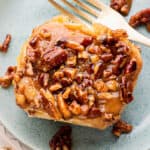 pecan sticky bun on blue plate with fork