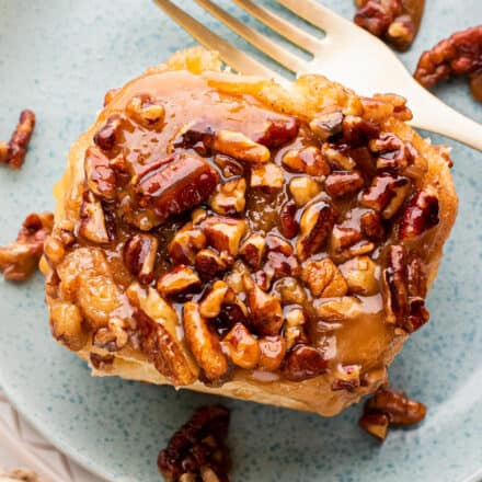 pecan sticky bun on blue plate with fork