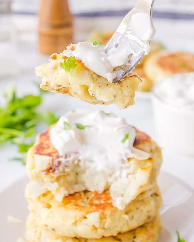 forkful of mashed potato pancake with sour cream on it