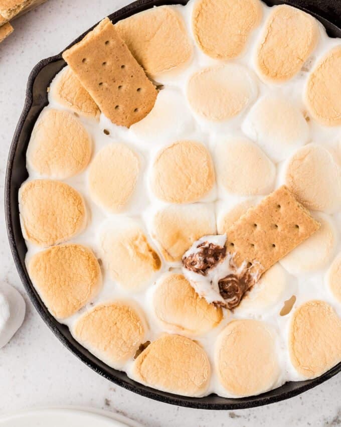 overhead view of smores dip with a graham cracker dipped into the melted chocolate